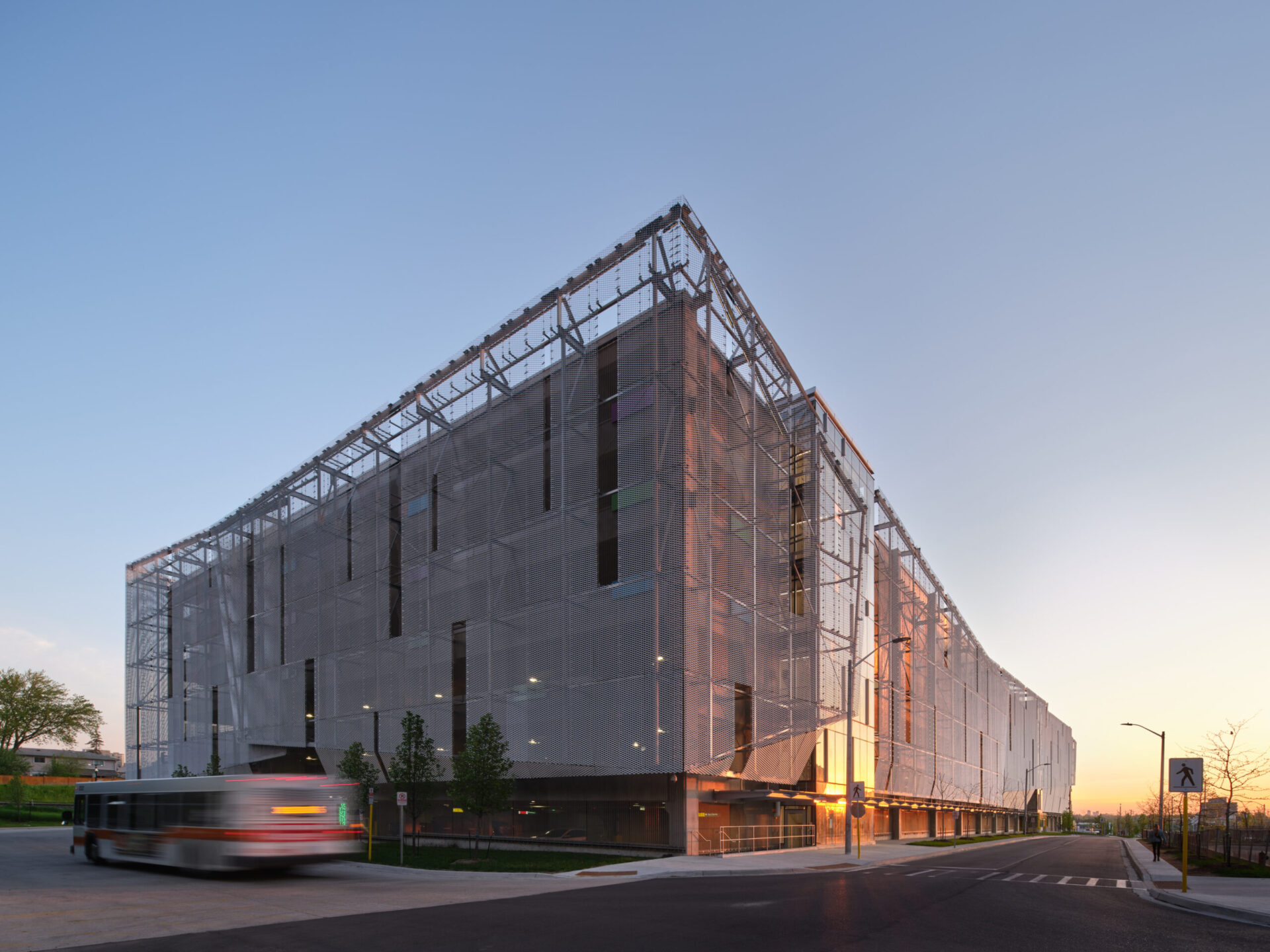 A grand glass structure showcasing the collaboration of engineering and architecture, complemented by the presence of a bus.