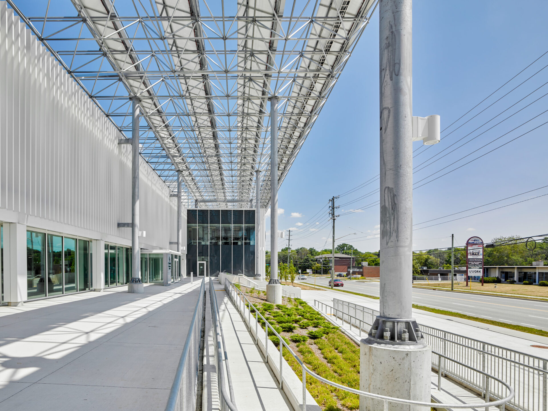 An architecturally engineered building featuring a walkway and a sleek metal roof.