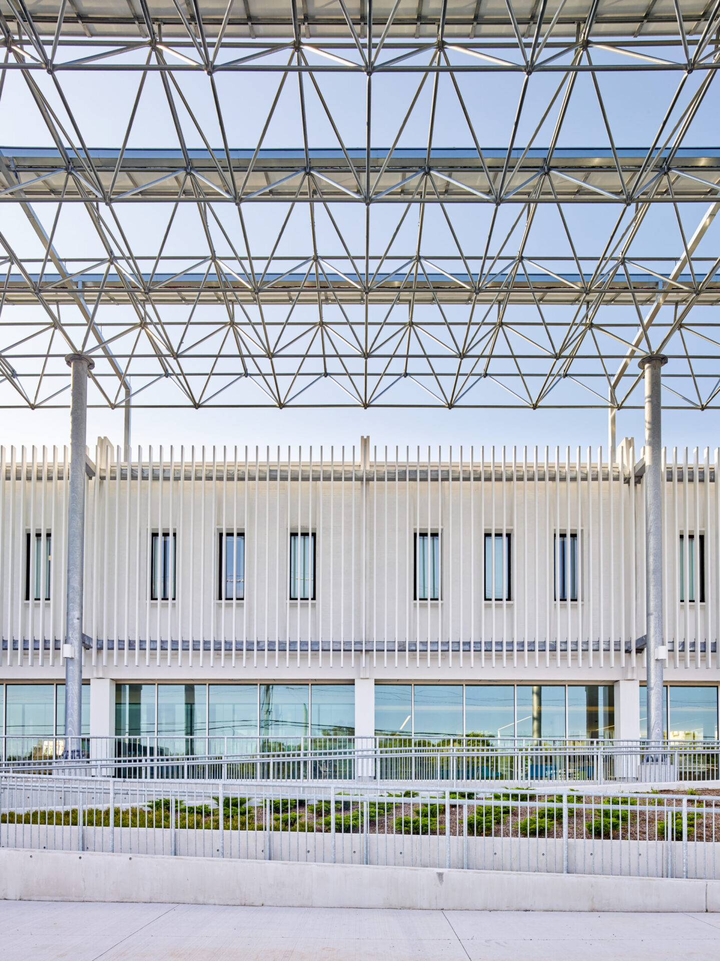 A building with a metal roof and glass windows designed by architects.
