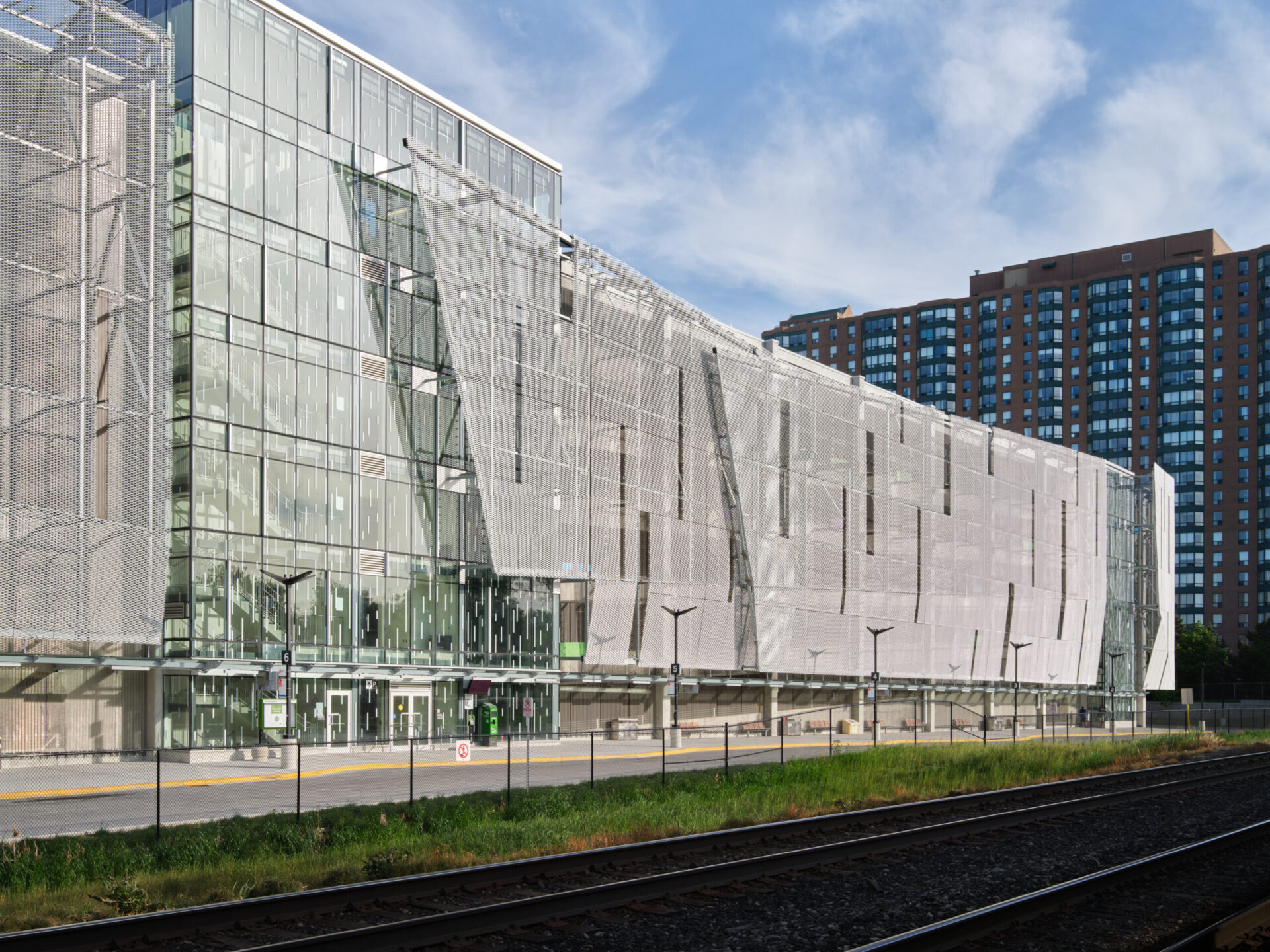 An architecturally impressive glass building featuring a train track.