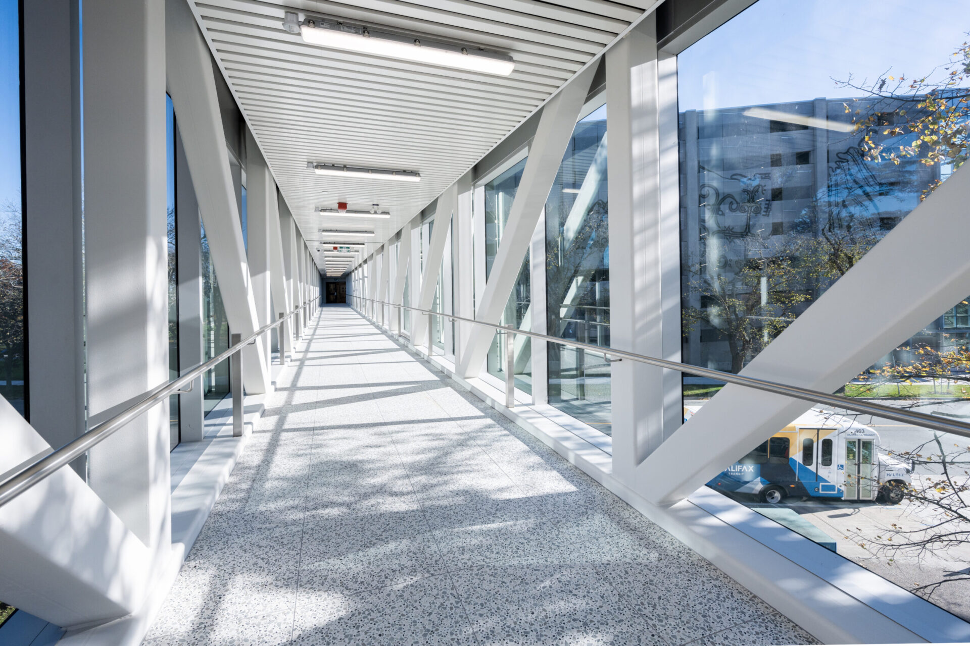 An architectural walkway featuring glass railings.