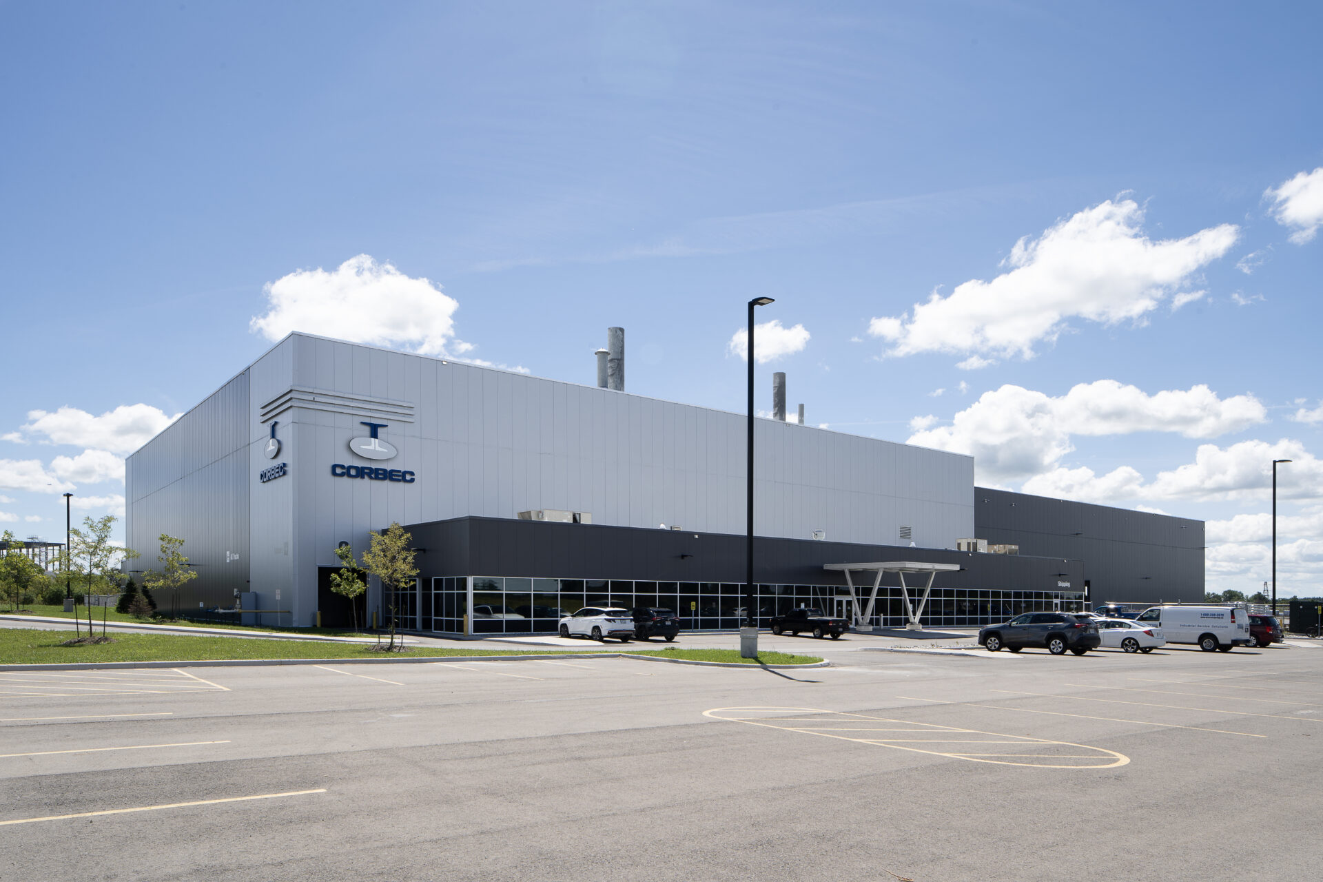 A large steel building with cars parked in front of it.