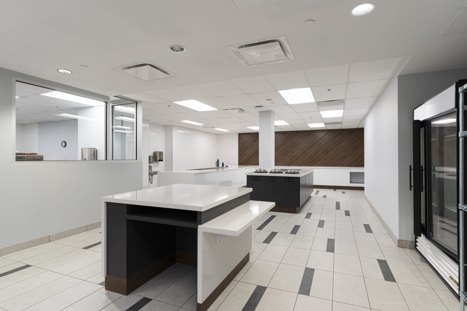 An architecturally designed kitchen with a refrigerator and a microwave.
