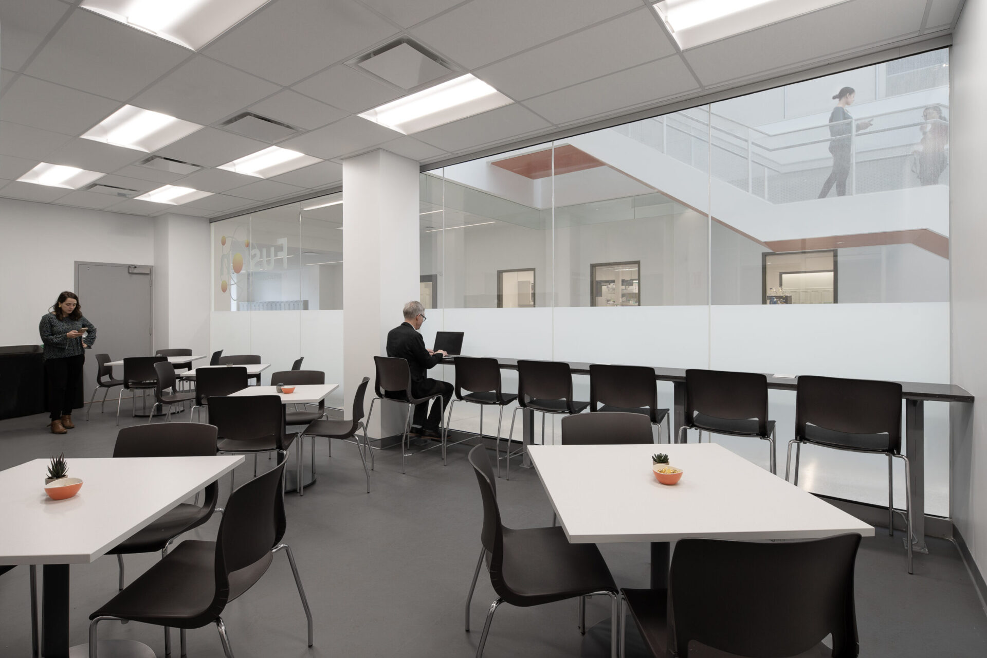 An engineering room with tables and chairs and a glass wall.