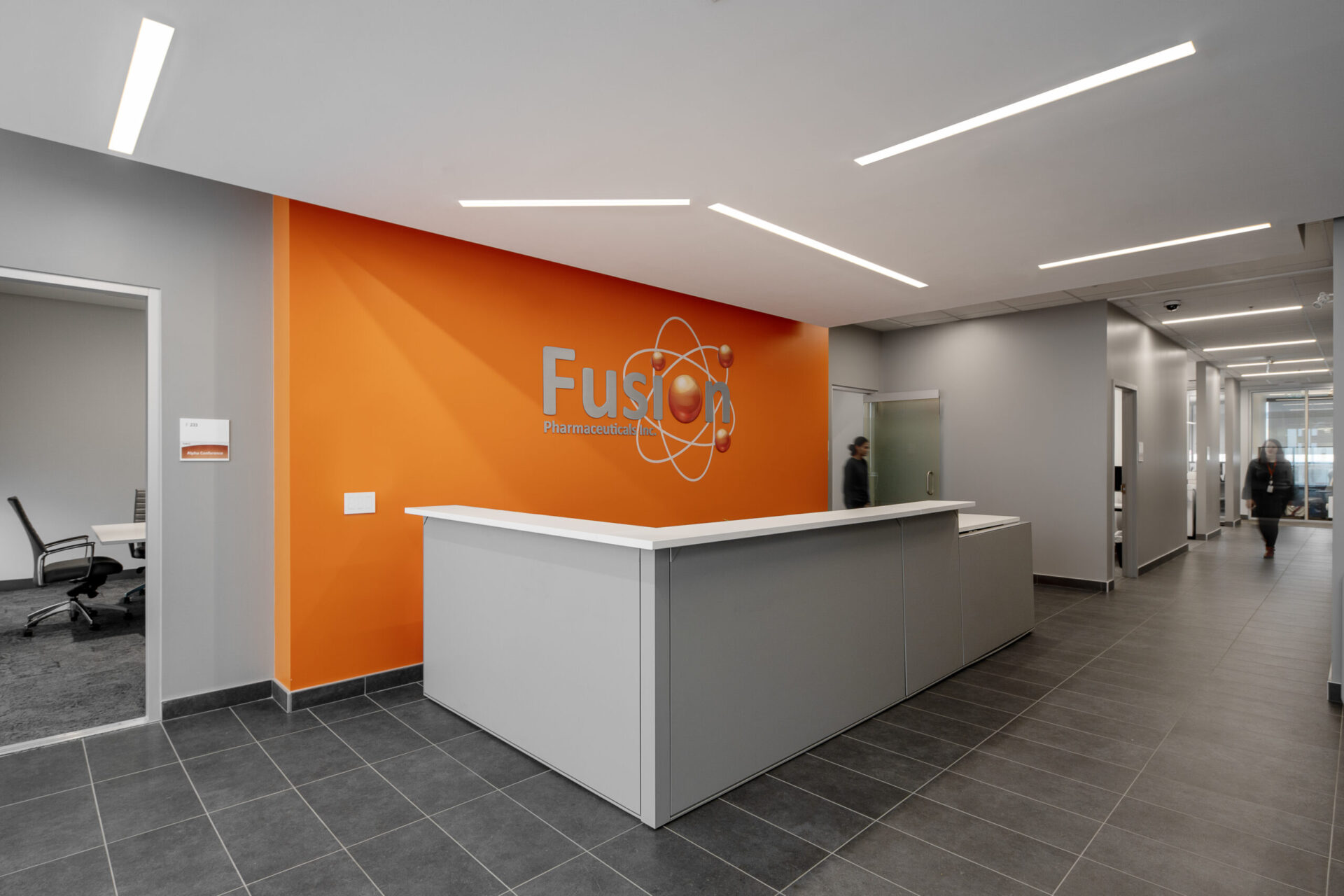 A reception area in an office with engineering-inspired design featuring orange and white walls.