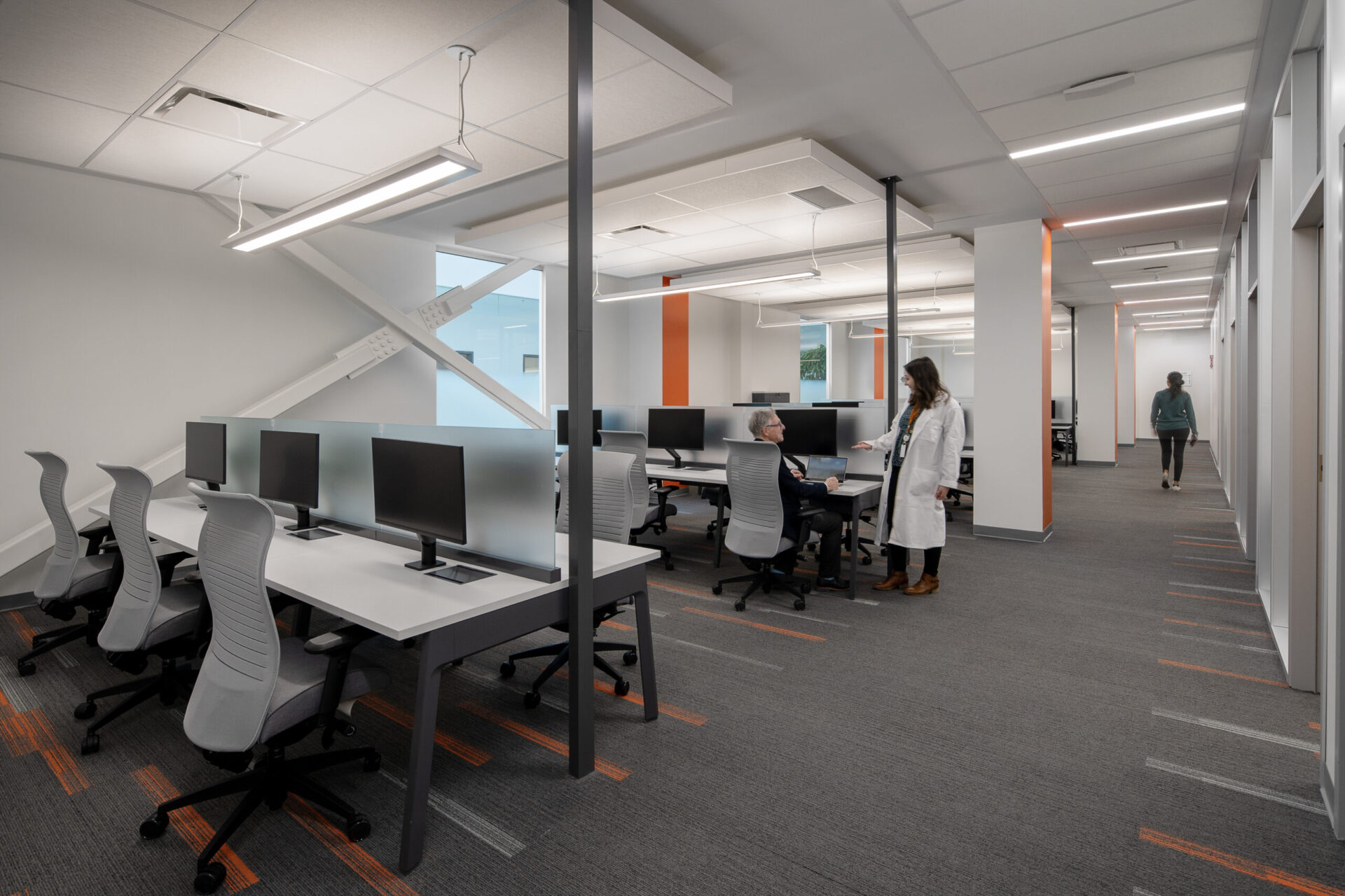 An image of a computer lab with people sitting at desks in an architectural setting.