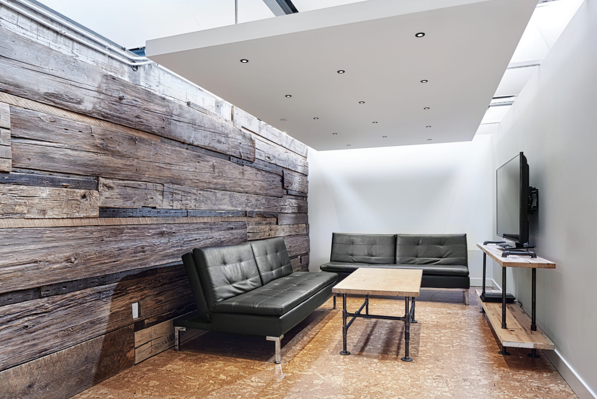 A living room with a wooden wall showcasing architectural design and comfortable couches.