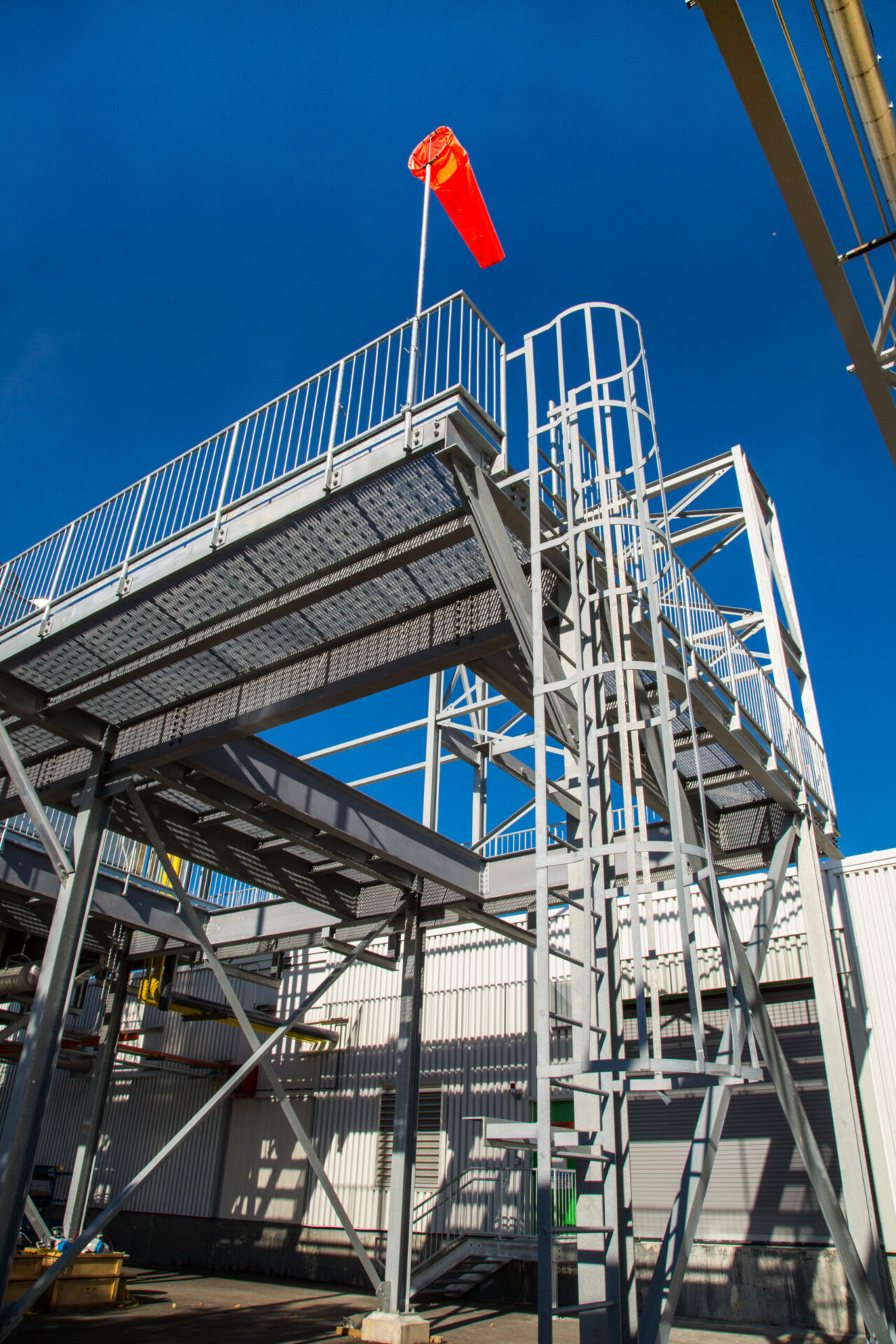 A metal stairway with a red flag, showcasing impressive architecture.
