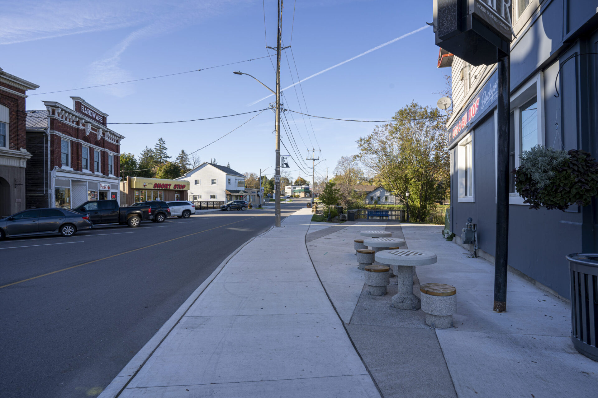 A city street with architectural features such as a sidewalk and benches.