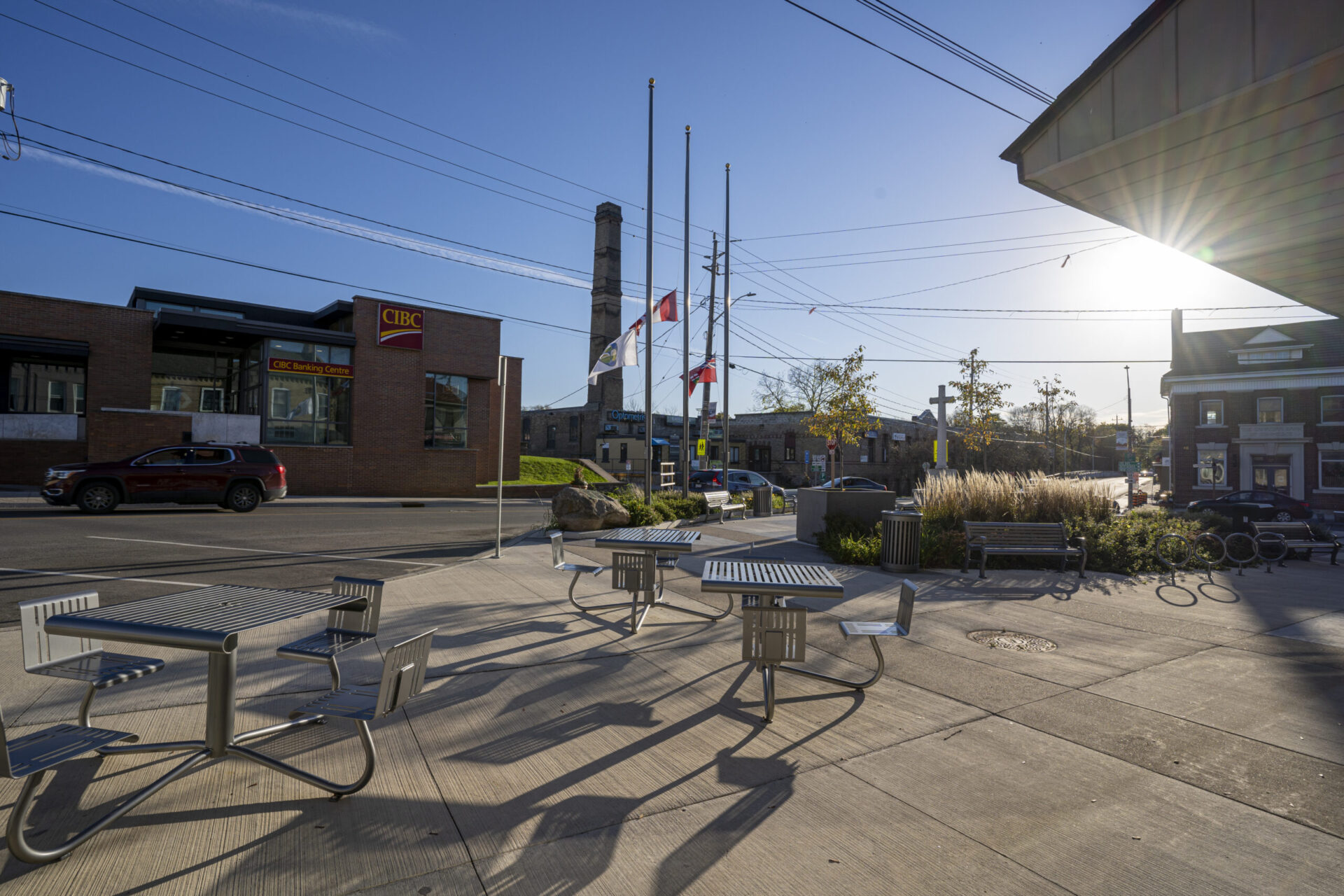 A sidewalk with tables and chairs designed with architectural consideration.
