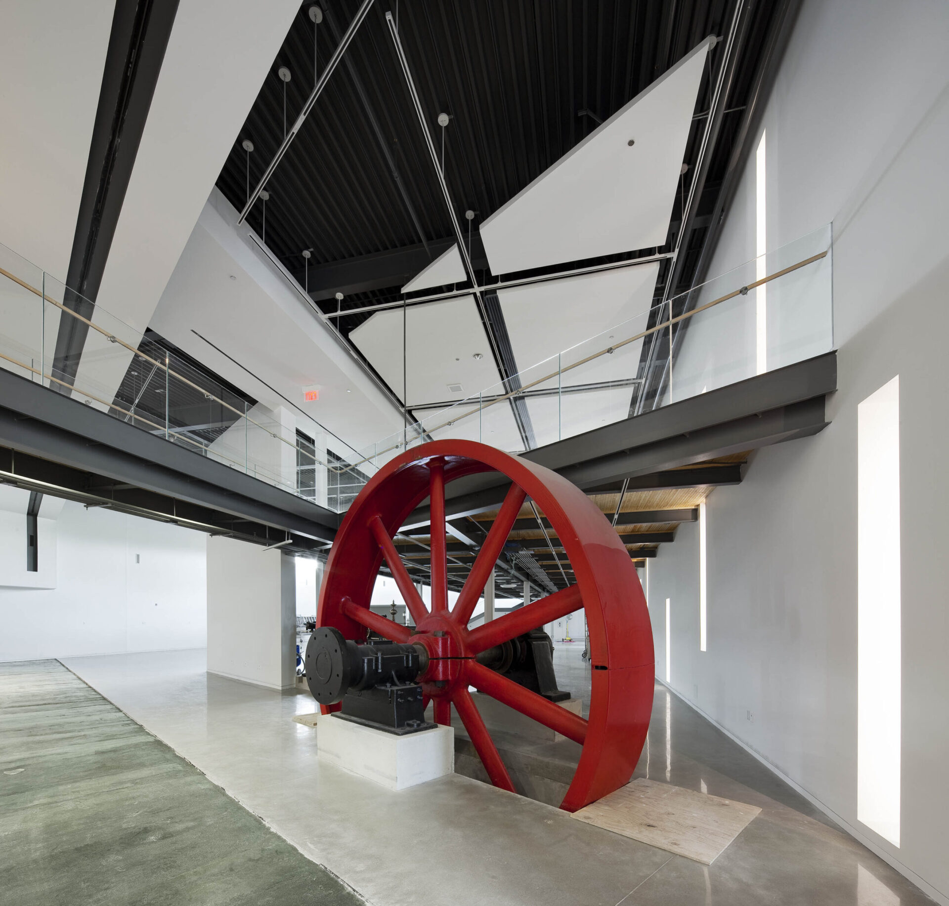 A large red wheel sits in the middle of an engineering room.