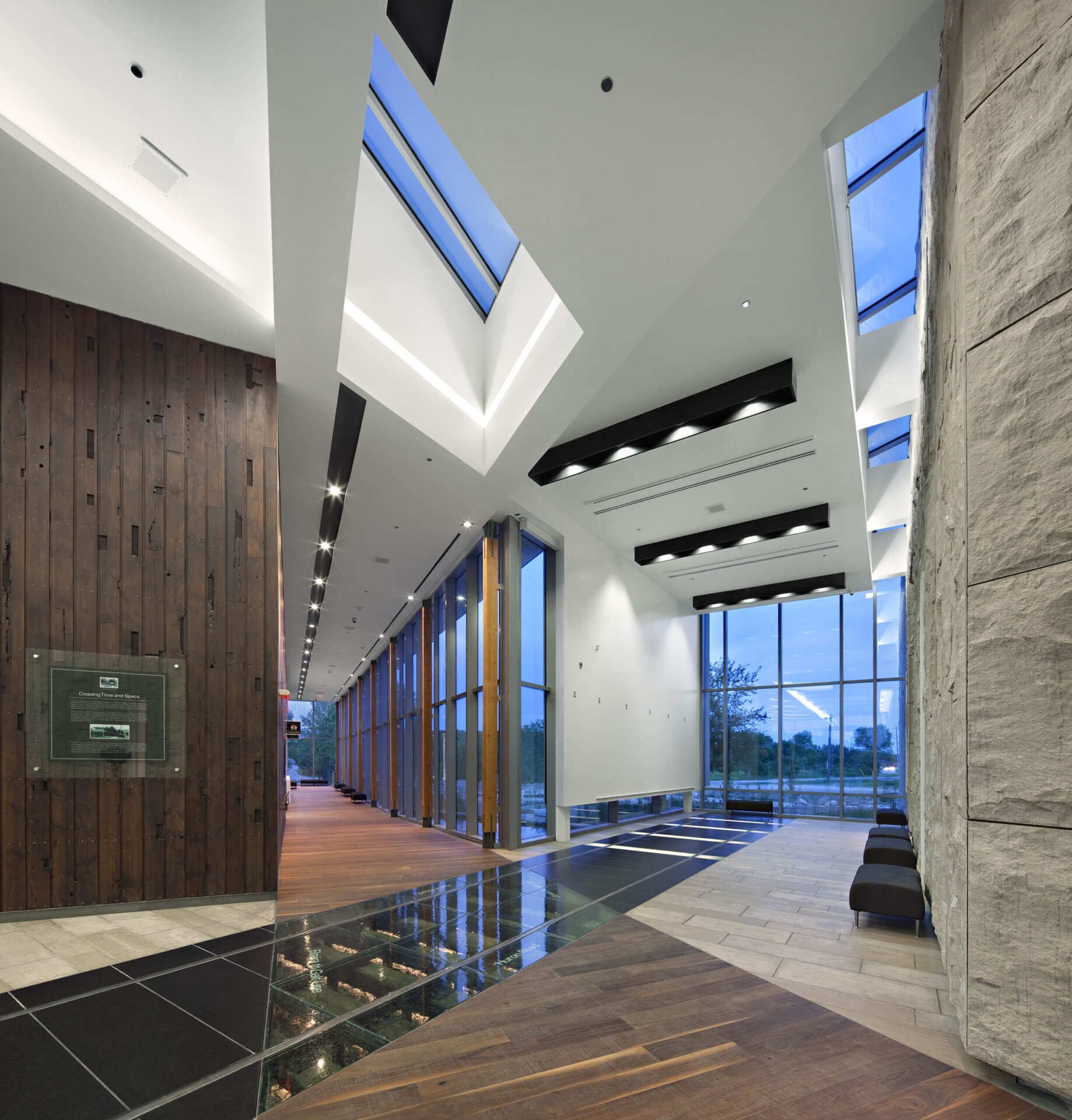 An architecturally designed lobby with a wooden floor and skylights.
