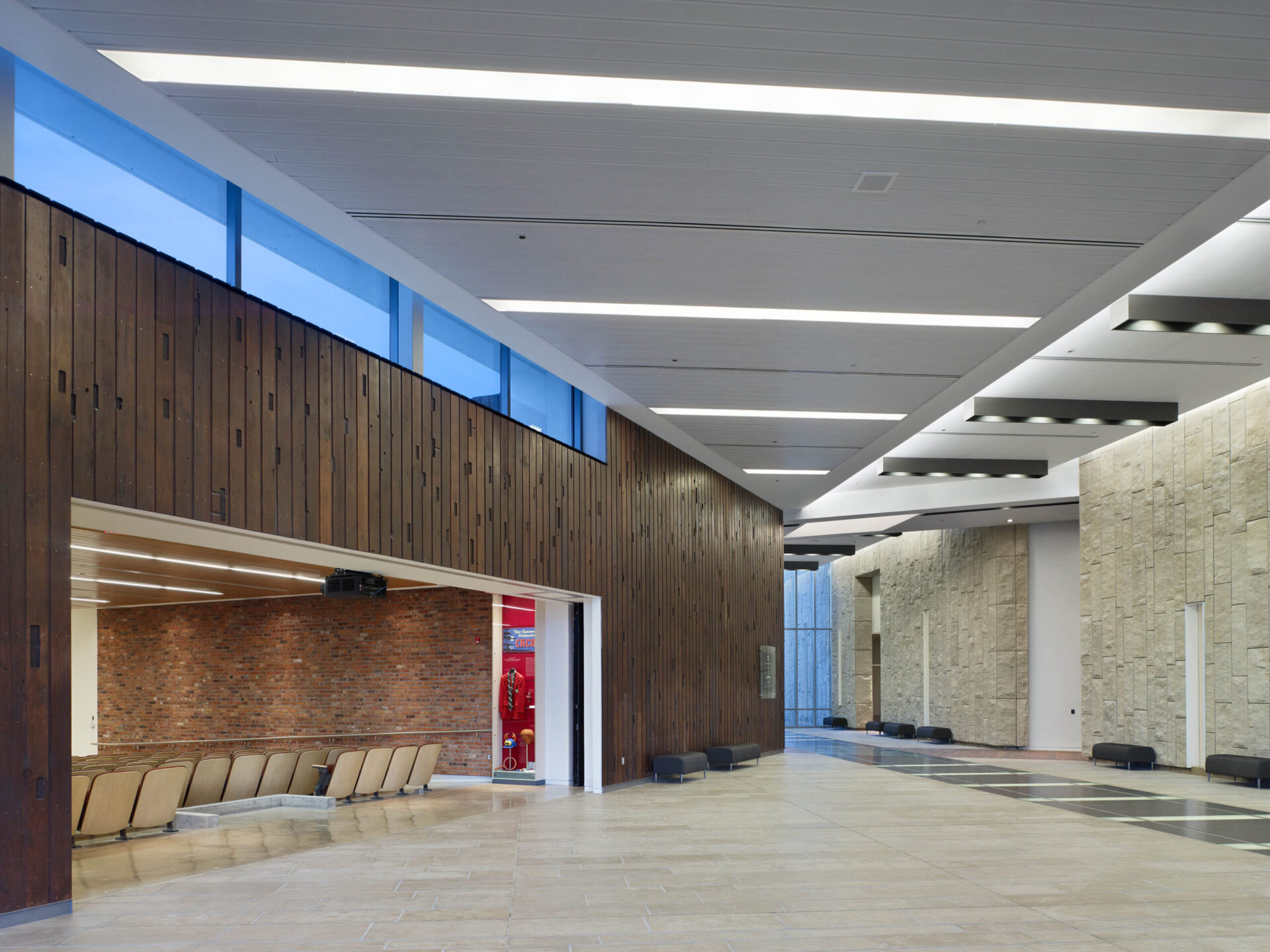 The lobby of a large architectural building with wooden walls.