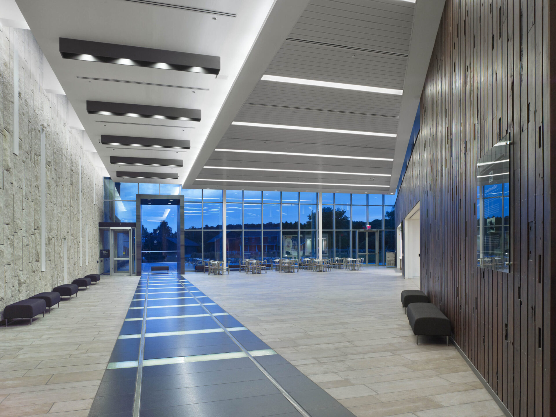 The lobby of an architecturally modern building with a glass wall.