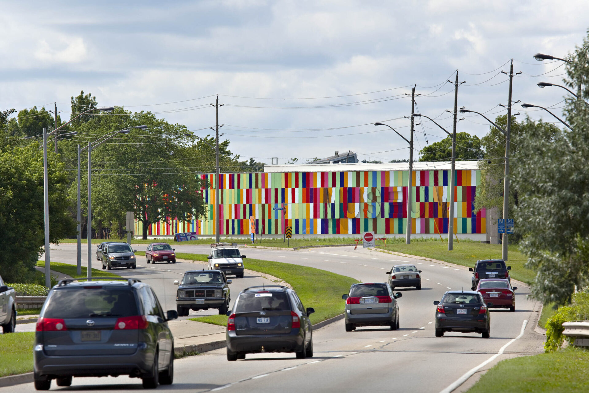 A car driving down a road lined with vibrant architectural structures.