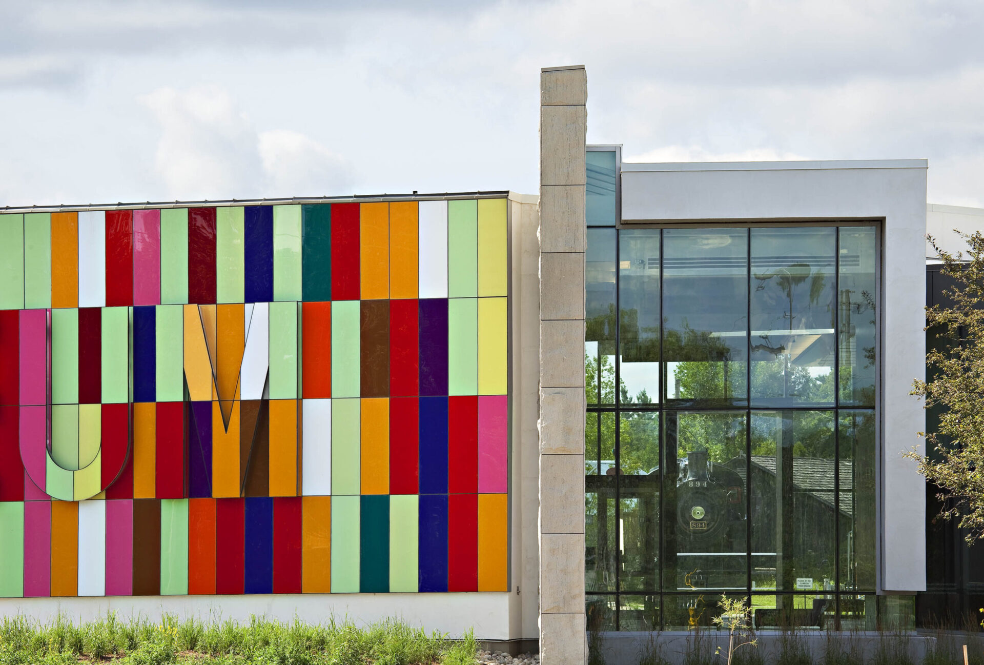 A colorful building showcasing architectural mastery with a tree gracefully positioned in front.