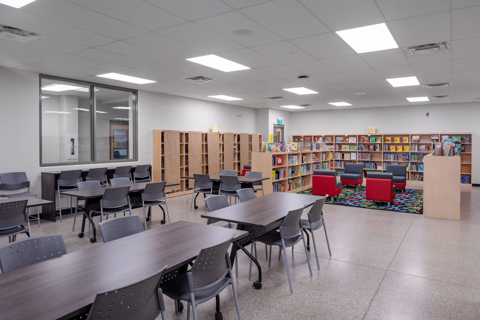 A school library with tables, chairs, and an architecture-inspired layout.