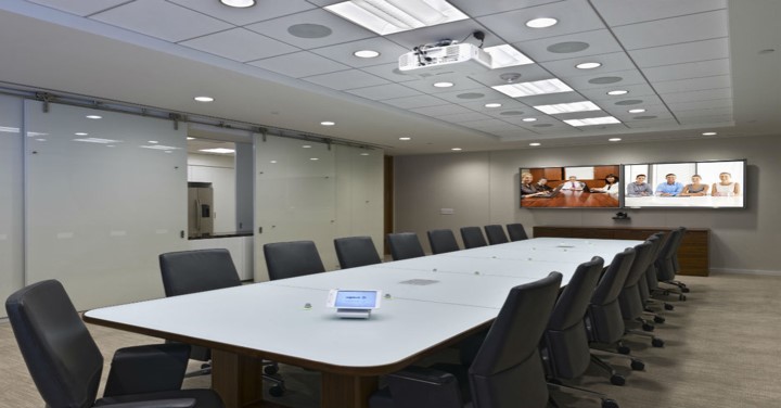 A conference room with a large table and chairs in a building.
