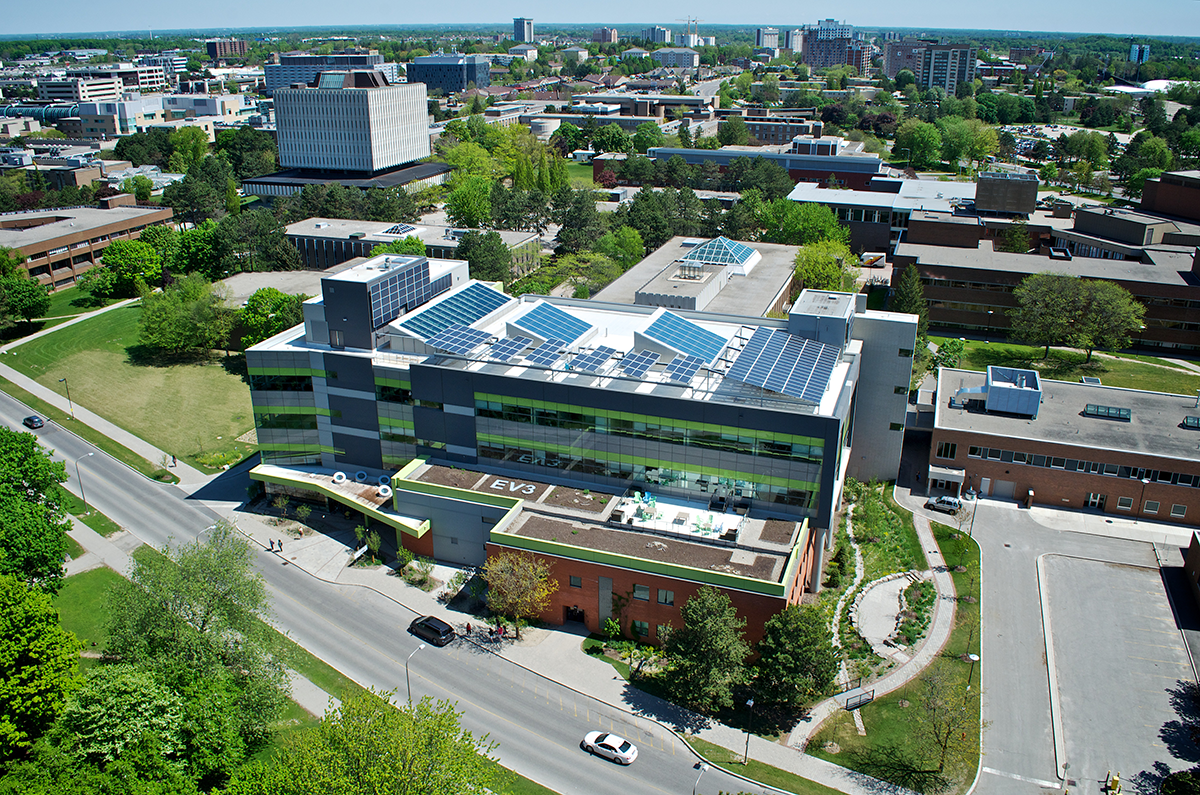 Overhead drone shot of a building with solar panels on the roof