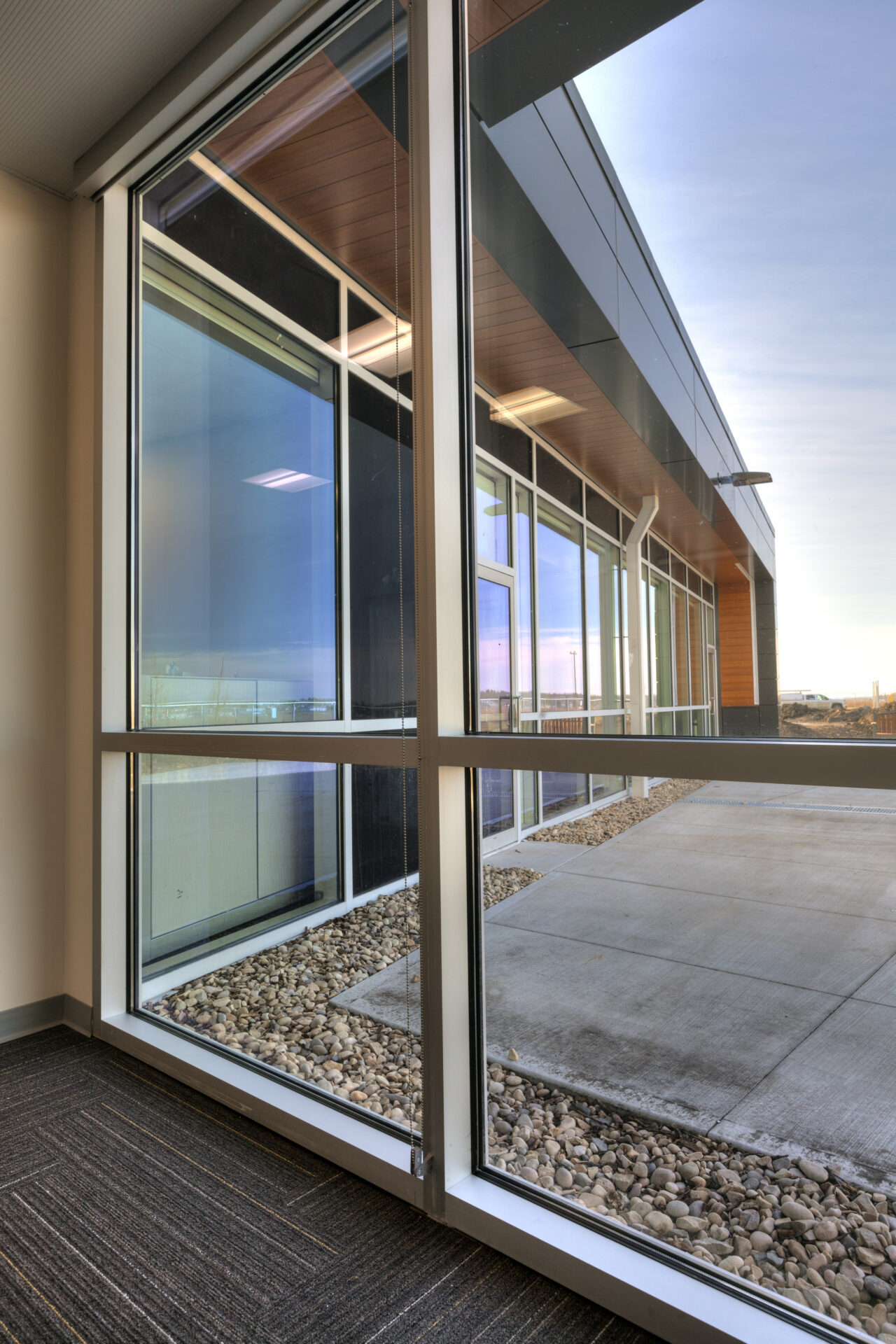 Floor to ceiling windows looking out to to the other side of the building with floor to ceiling windows. Afternoon to evening light.