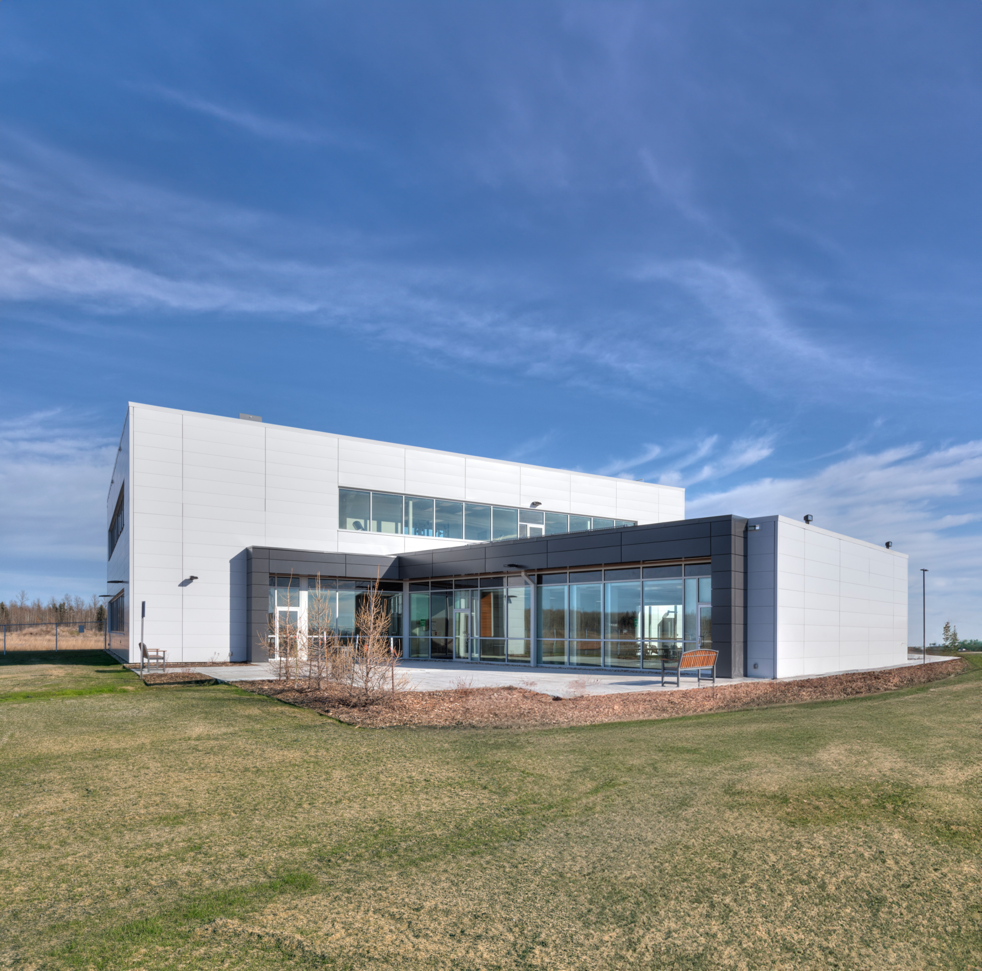 Front exterior of the building, showcasing the obtuse angle between the one storey portion of the building compared to the two storey portion building. It is set on a bright sunny day.
